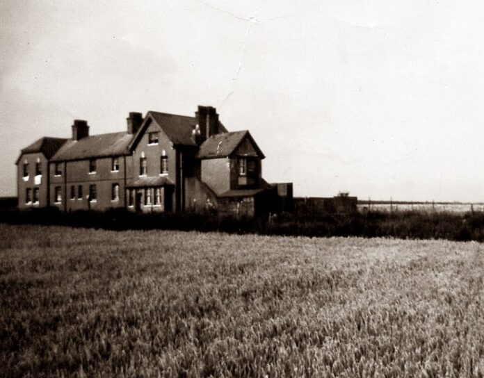 grayscale photo of house on grass field