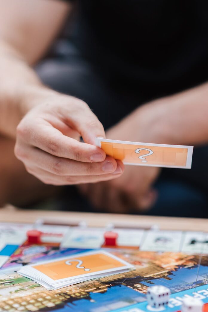 pexels-photo-4792366 faceless player with monopoly card at table